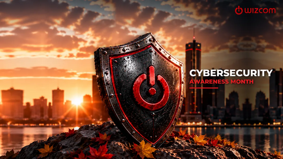 A steel shield with a red power symbol resting on a rock among autumn leaves, in front of the Detroit skyline at sunset, with the words Cybersecurity Awareness Month